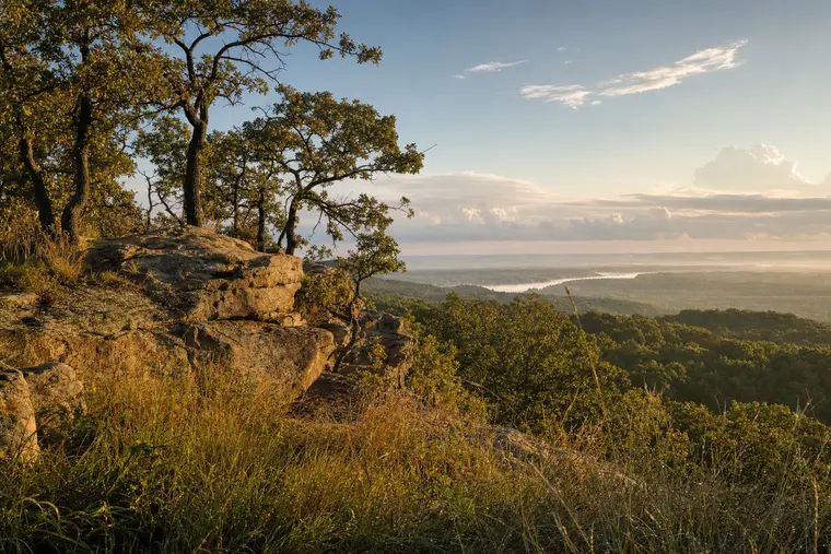 Sandstone outcrop and oak hills above the Arkansas River valley west of Sand Springs